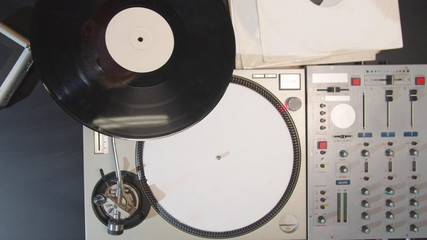 The musician removes the record from the turntable