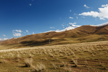 electricity pylons in the mountains, Naryn region in Kyrgyzstan. Mountain landscape
