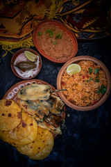 Mexican vegetarian food in clay dishes on dark background