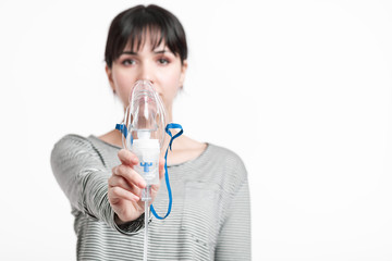concentrated woman holding inhalation mask in front of her face. pulmonary diseases recovery...