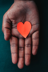 Hand holding paper cut out of heart