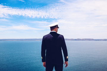 Strong posture of a captain looking at the sea and faraway land on the horizon. Navy/Cruise ship...