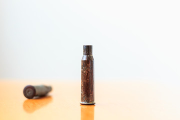 The rifle cartridges old, rusty, military on wood table.