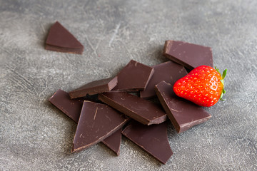 Dark chocolate with strawberry isolated on grey background. 