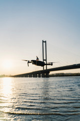 Fototapeta na wymiar flying drone at sunset over the river