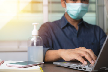 Asian male employee wearing a health mask and alcohol gel to Preventing corona virus infection...