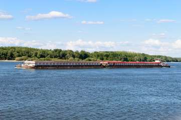 Long barge on the river in sunny weather