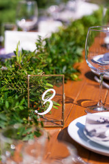 Preparing for an open-air party. Decorated with fresh flowers served tables. Table number. Decoration Details