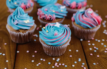 Pink and blue cupcakes on a natural wooden background