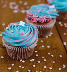 Pink and blue cupcakes on a natural wooden background