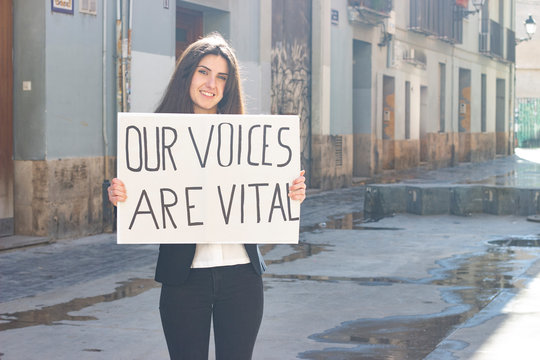 Attractive  Young Woman Activist Hold Up Protesting Sign Saying 