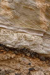 Volcanic Ash, Brecia and Lava Flow layers on a rock face within a small Valley one the Island of Tenerife.