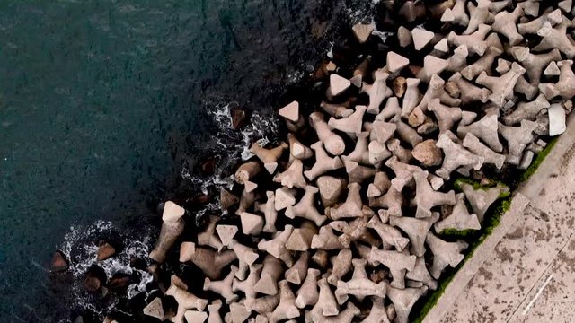Aerial footage from the Port of Constanta. Top view of the Black Sea hitting the shore.