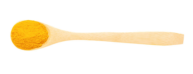 Top view isolated wooden spoon with turmeric powder.