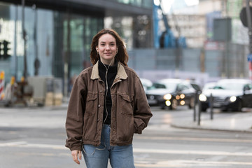 Obraz premium Natural Beauty Smiling on Street Listening to Earphones