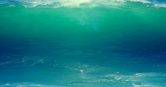 Big ocean wave slow motion. Blue emerald sea water of huge, giant, large, extreme ocean wave crash, splash, spray  at beach coast. Hurricane storm wind wave slow motion.
