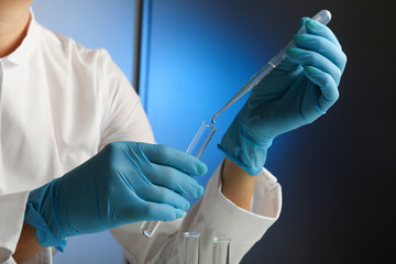 medical scientist drops the liquid with a dropper into a test tube close up. chemist works with lab...