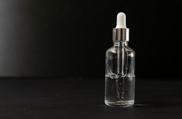 Obraz na płótnie Canvas half filled vial of hyaluronic acid hyaluronan on a dark background