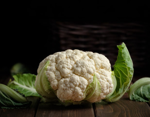vegetable cauliflower head fresh raw vegan food ingredient still life dark wood background with copy space