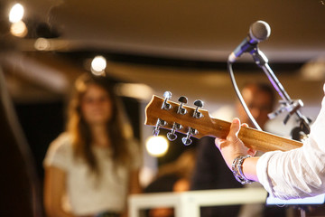 chitarra in primo piano durante un concerto e sullo sfondo il pubblico sfocato