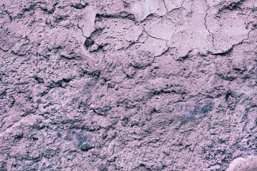 A cement wall with a rough surface. Grey natural background with small cracks. Dried concrete facade for 3D design. Processing in the purple spectrum.