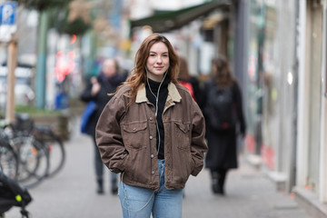 Young Woman Posing on Street with Hands in Pockets