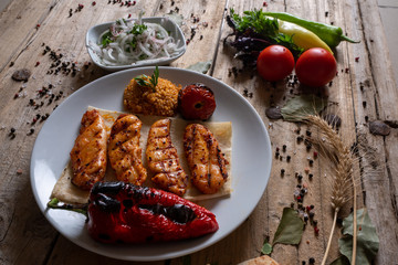 Kebabs - grilled meat and vegetables. Grilled chicken breast. Fried chicken fillet and fresh vegetable salad of tomatoes, cucumbers and arugula leaves.
Grilled chicken legs with spices and garlic.