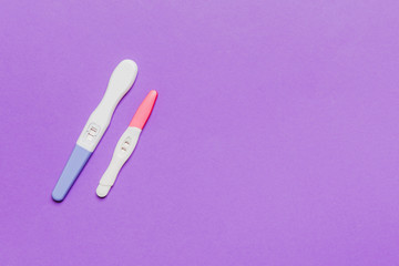 Colored Pregnancy test on colored background, top view with copy space