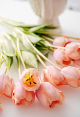 Fototapeta na wymiar A few light pink tulips on the table. Festive mood of flowering.