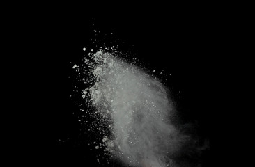 White powder explosion isolated on black background.