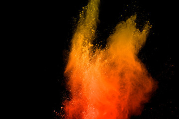 orange powder explosion isolated on black background.Colored dust splash.