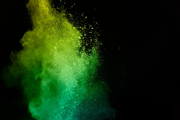 green powder explosion isolated on Black background.Colored dust splash isolated.