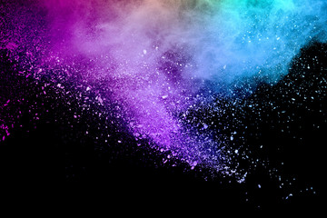 Colored powder explosion on black background. Freeze motion.