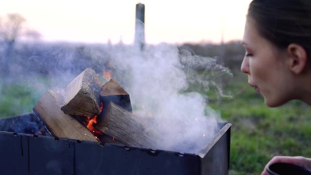Close up of a beautiful brunette female who blowing fire