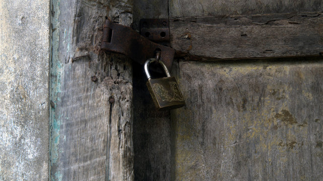 Candado cerrando puerta de madera vieja.