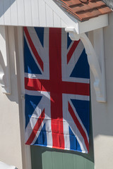 Fototapeta na wymiar A Great Britain flag hung on the front door of a house for VE day celebrations.