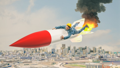 smiling handyman with hard hat flies clinging to a large rocket above the city.