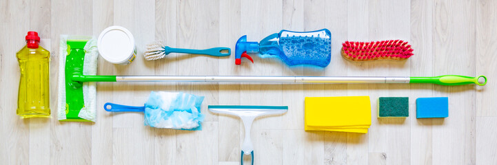 Web banner flat lay with collection of cleaning materials on a light wooden background