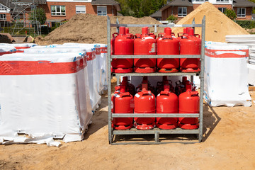 pallet with red gas bottles is standing on a construction site
