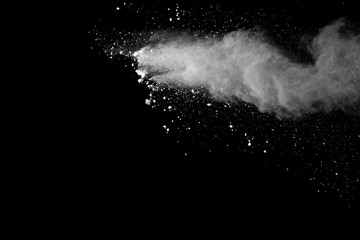 Freeze motion of white color powder exploding on black background.