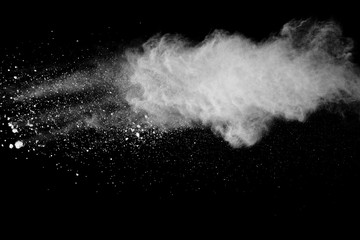 Freeze motion of white color powder exploding on black background.
