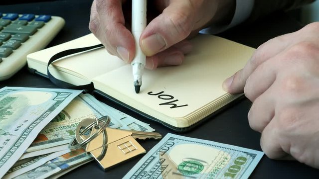 Man writes mortgage pros and cons. Loan for buying property.