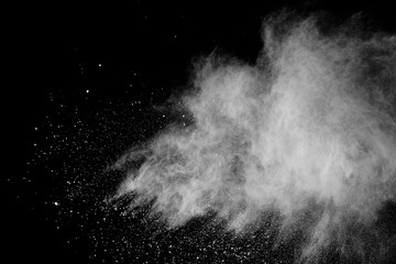 Freeze motion of white color powder exploding on black background.