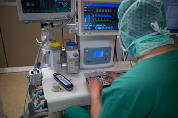  anaesthetist makes computer entries on the anaesthesia machine