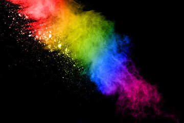 Multi colored dust splash on black background.Painted Holi.Colorful background of pastel powder explosion.