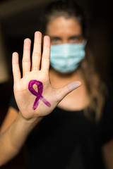 Mano pintada con un lazo lila para el Día Internacional de la Fibromialgia (12 de mayo del 2020)