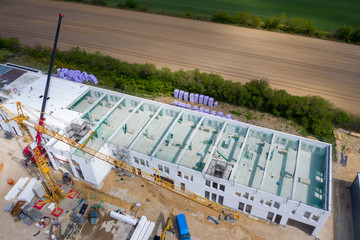 drone photograph of a large construction site on which a large factory hall is being built