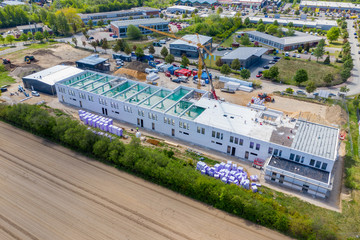 drone photograph of a large construction site on which a large factory hall is being built