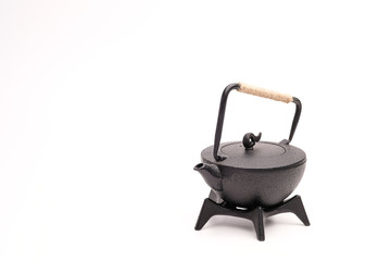 Black metal cast-iron traditional teapot on white background.