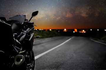 Sports bike at night. On the horizon the city and the starry sky